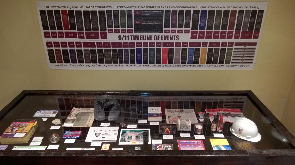 Educational exhibit with a 9/11 timeline of events and a display case of preserved artifacts